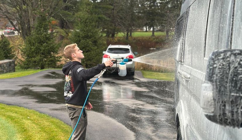 Technician spraying foam on a large grey van